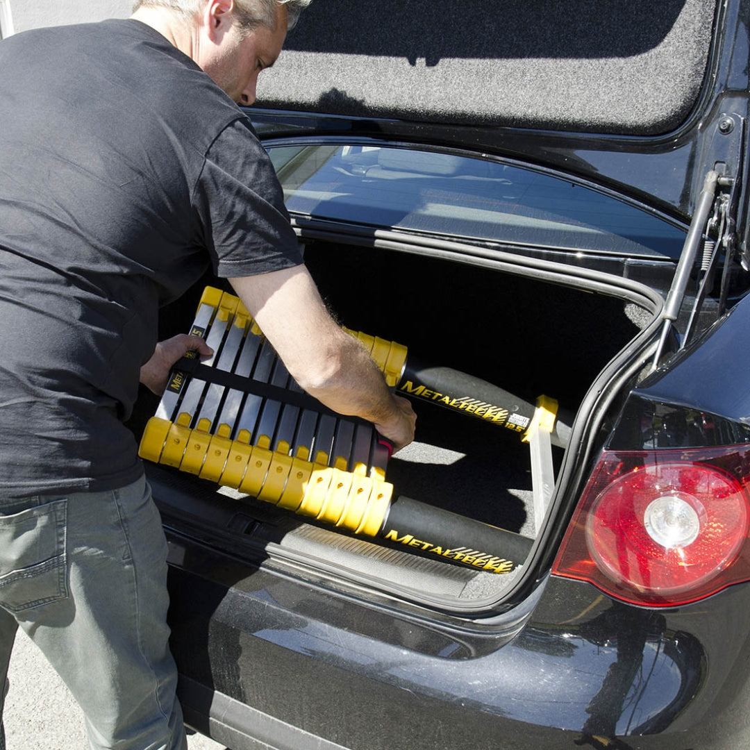 Compact Metaltech telescopic ladder being placed inside a car trunk